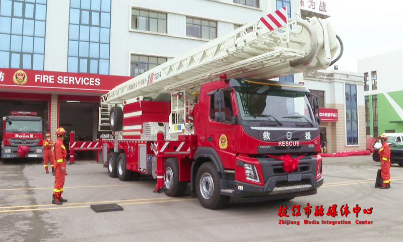 登高平台消防车从市消防救援大队车库内缓缓驶出,在空地上进行了云梯