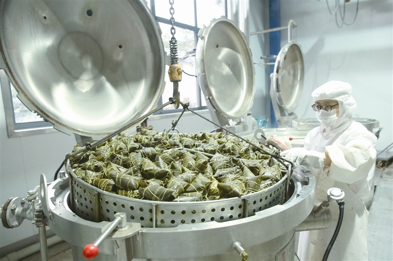 5月23日,秭归县一家食品加工企业的工人在粽子生产车间煮粽子.